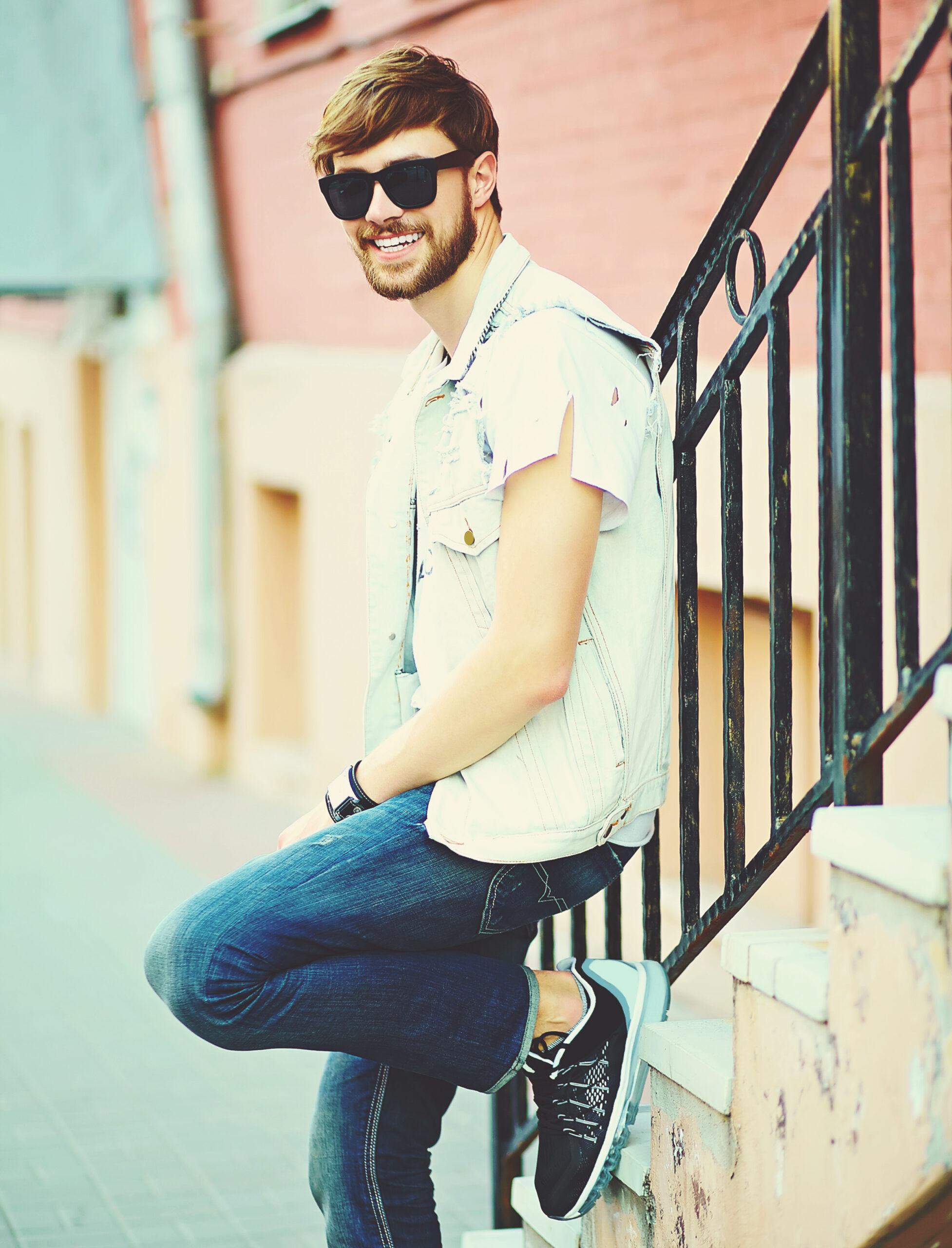 funny smiling hipster handsome man guy in stylish summer cloth in the street in sunglasses