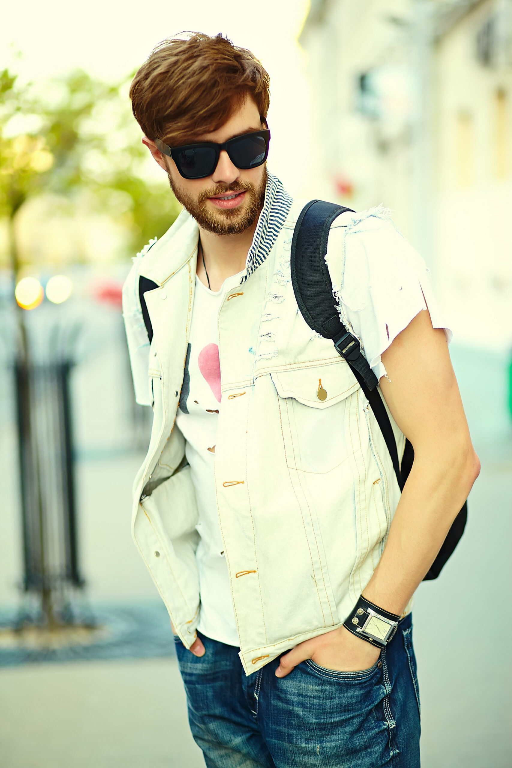 funny smiling hipster handsome man guy in stylish summer cloth in the street in sunglasses